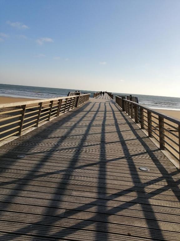 une longue promenade menant à la plage avec une longue ombre dans l'établissement Domaine de la lumière, à Saint-Jean-de-Monts