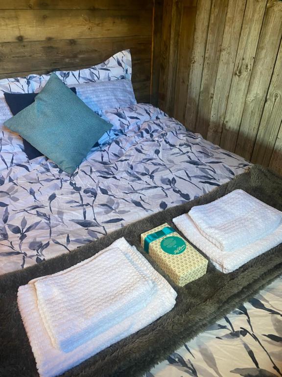 a bed with blankets and pillows on top of it at Swallowfield Glamping-Station Master in Yeovil