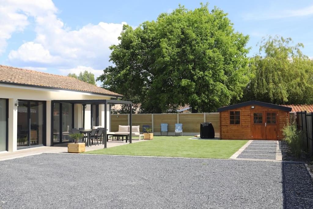 une maison avec une cour dotée d'une terrasse et d'herbe dans l'établissement Maison Contemporaine Andernos, à Andernos-les-Bains