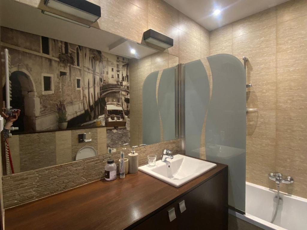 a bathroom with a sink and a mirror at Stylowy Apartament in Warsaw
