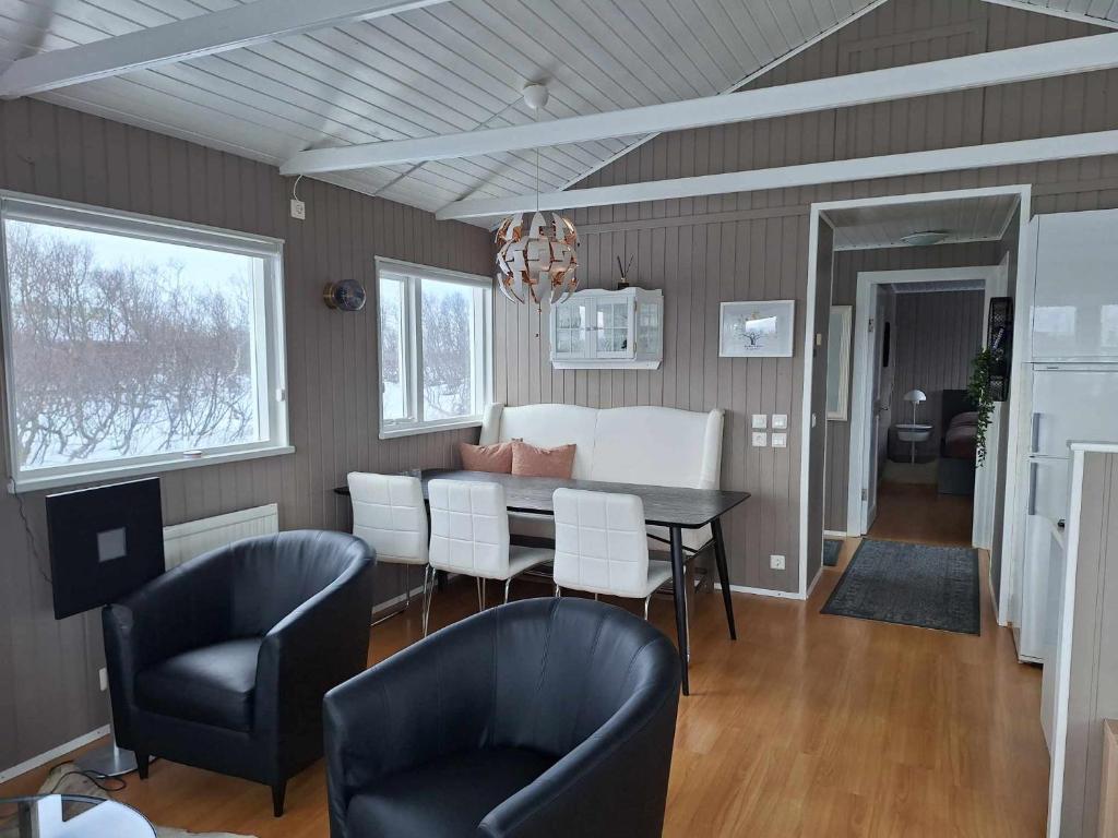 - une salle à manger et un salon avec une table et des chaises dans l'établissement Dimond cottage, à Laxamýri
