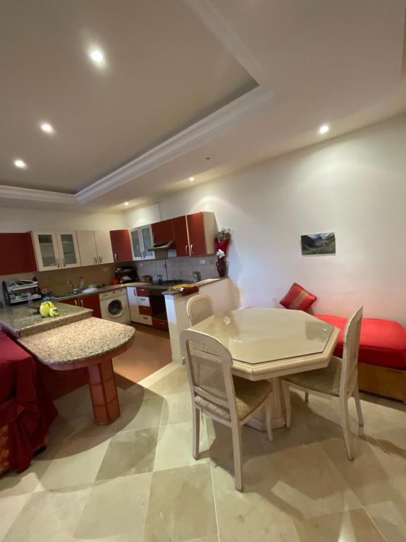 een keuken en een woonkamer met een tafel en stoelen bij 40€/j شقة غرفة نوم 1 في فيلا حي النصر in Ariana
