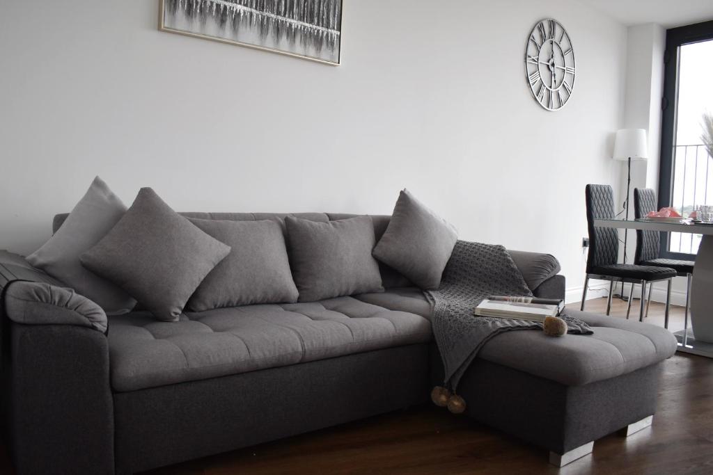 a gray couch in a living room with a table at Modern two bedroom in Brentwood London in Brentwood