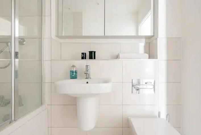 a white bathroom with a sink and a shower at Private Room Near Stansted Airport in Bishops Stortford