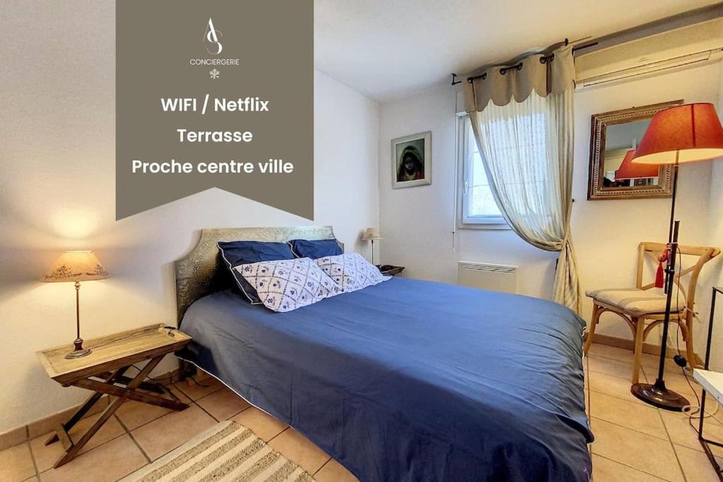 a bedroom with a blue bed with a table and a chair at Le Stadium - 2 pers - Proche Centre - Mouans-Sartoux in Mouans-Sartoux