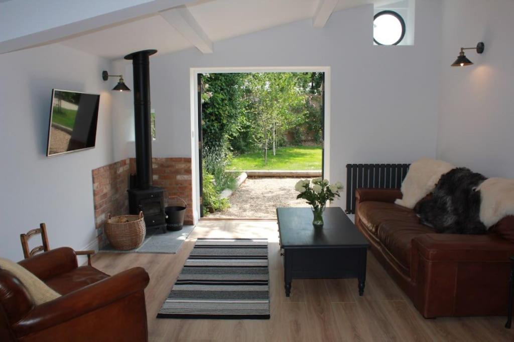 a living room with a couch and a fireplace at The Pitstop in Sidlesham