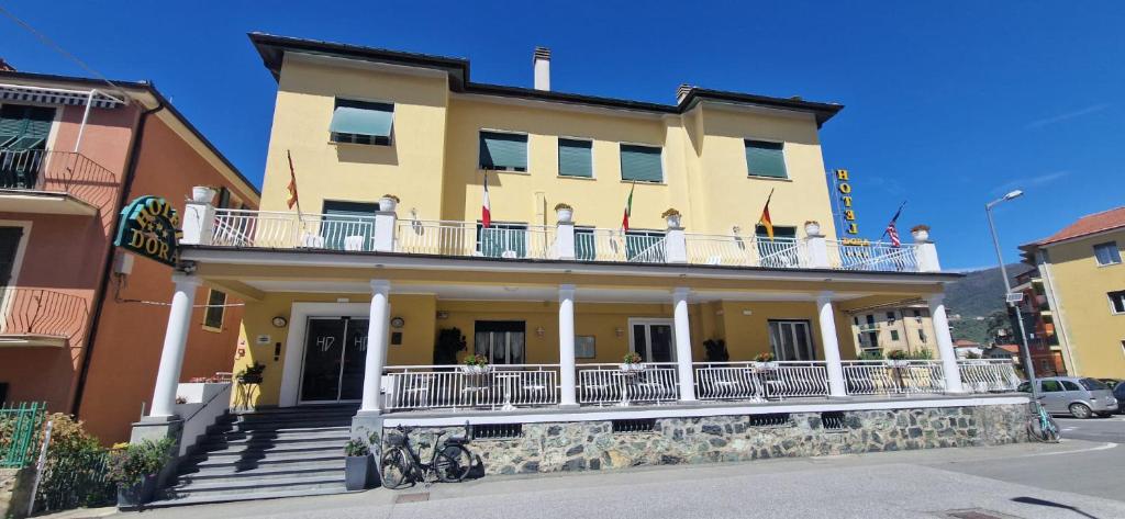 ein großes gelbes Gebäude mit Balkon auf einer Straße in der Unterkunft Hotel Dora in Levanto