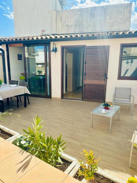 a backyard with a patio with a table and chairs at Holiday House Valpiè in Avola