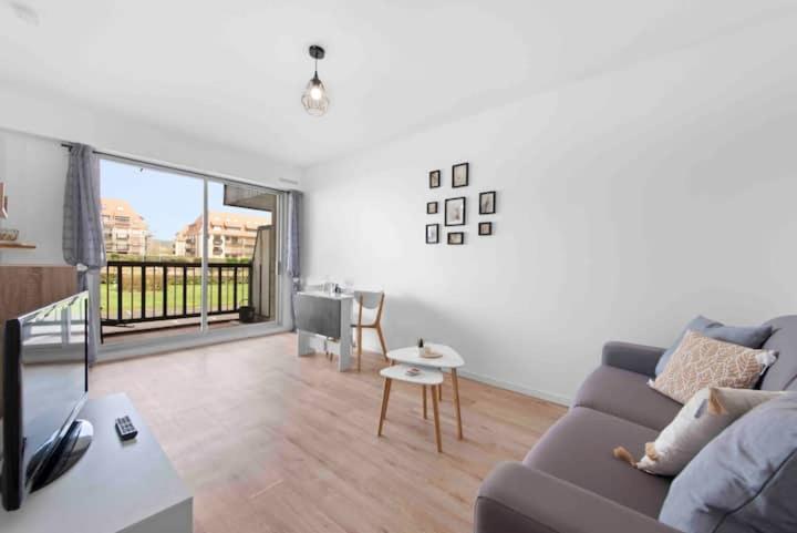 un salon avec un canapé et une table dans l'établissement Un Cocon au Bord de l'Océan Vue Partielle sur Mer, à Villers-sur-Mer