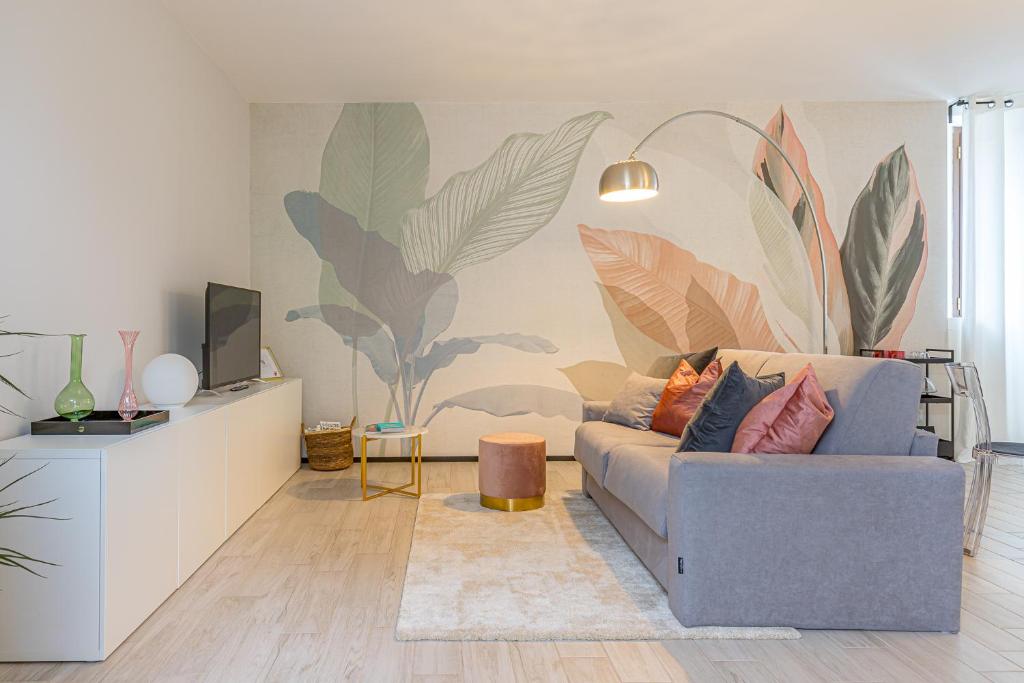 a living room with a couch and a wall with plants at At Home-Como Lake in Como