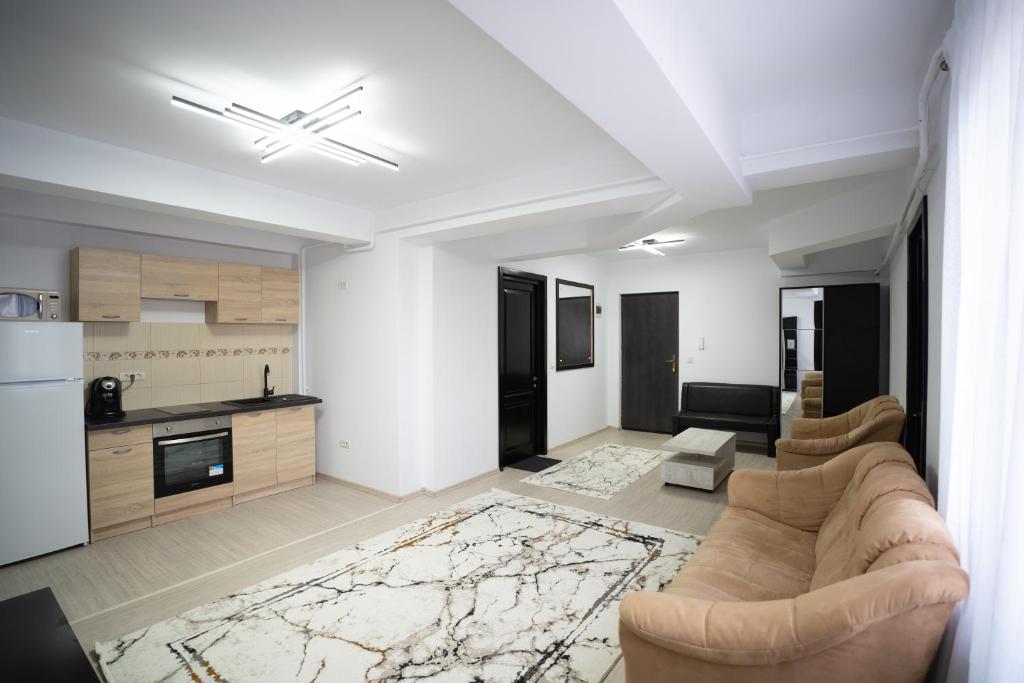 a living room with two couches and a kitchen at Alex 1 Apartament in Iaşi