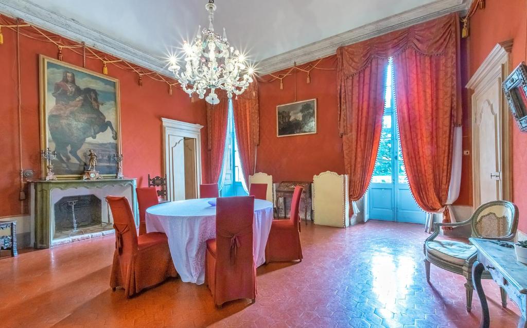 una sala da pranzo con tavolo e lampadario pendente di Castello Canalis a Cumiana