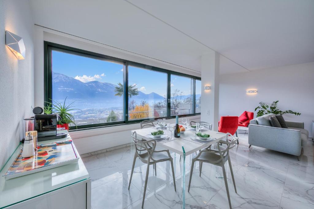 sala de estar con mesa, sillas y ventana grande en Wonderful Blick Apartment Orselina - Happy Rentals, en Orselina