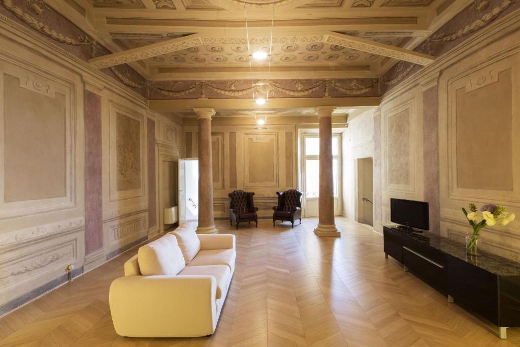 salon z białą kanapą i telewizorem w obiekcie Appartamento Suite Imperiale w mieście Cortona