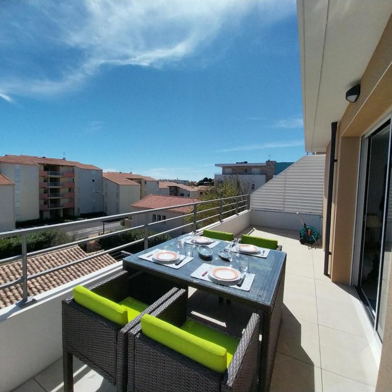 d'un balcon sur le toit avec une table et des chaises. dans l'établissement Superbe T3 wifi climatisé, Le Sunset Lodge, Narbonne Plage, à Narbonne-Plage