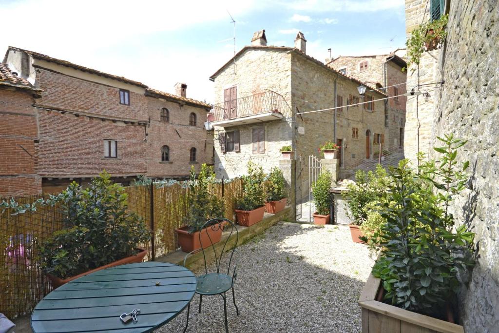 eine Terrasse mit einem Tisch und Pflanzen im Innenhof in der Unterkunft Casa Caterina in Cortona