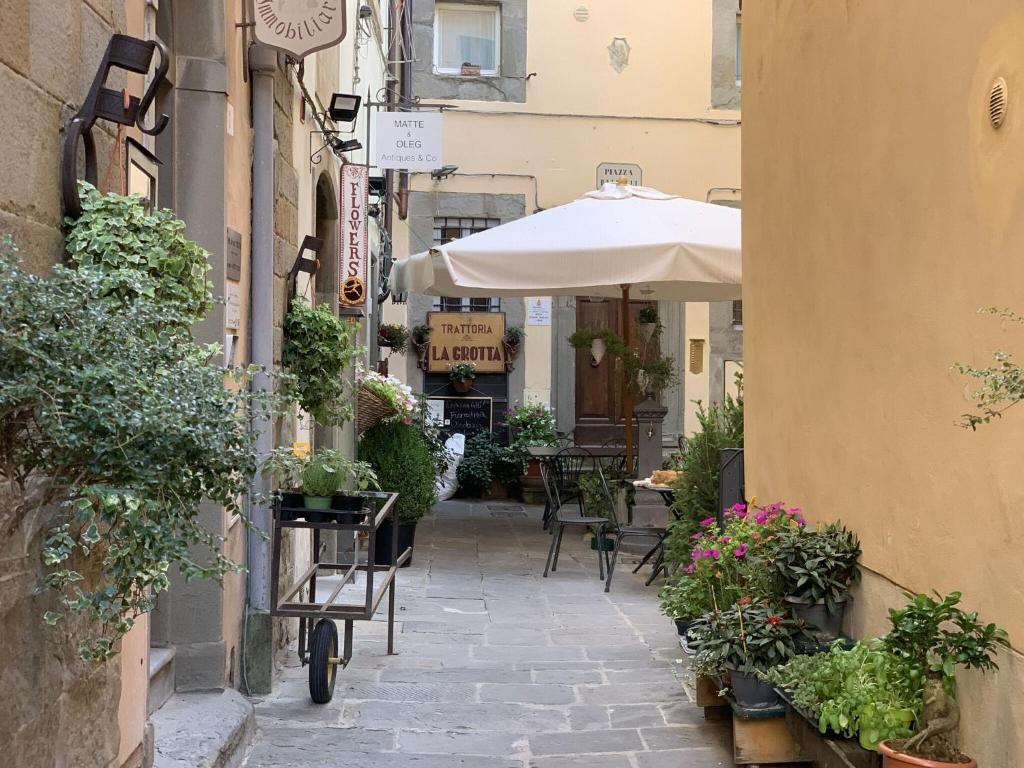 un callejón con una mesa y una sombrilla en Casa Annateresa en Cortona