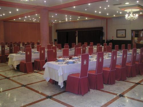 a large banquet hall with tables and red chairs at Hotel Begoña Park in Gijón