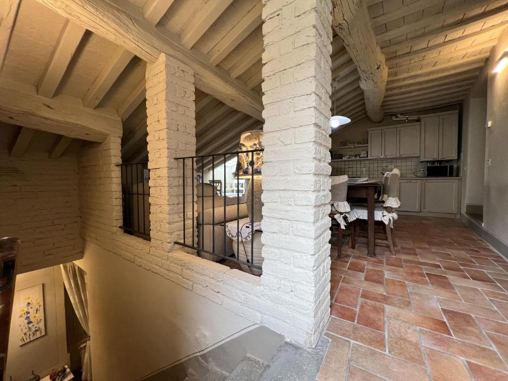 une cuisine et une salle à manger avec un pilier en pierre dans l'établissement Casa Degli Angeli, à Cortone