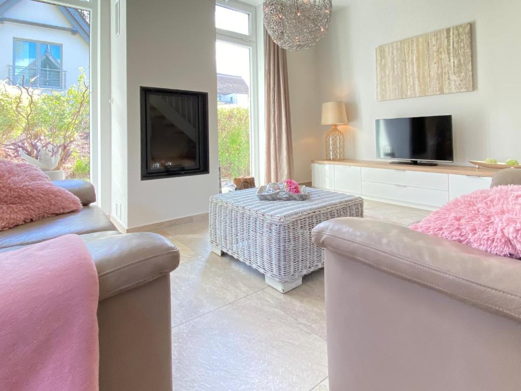 ein Wohnzimmer mit 2 Sofas und einem TV in der Unterkunft Ferienhaus am Lotsenstieg 6 in Ostseebad Karlshagen