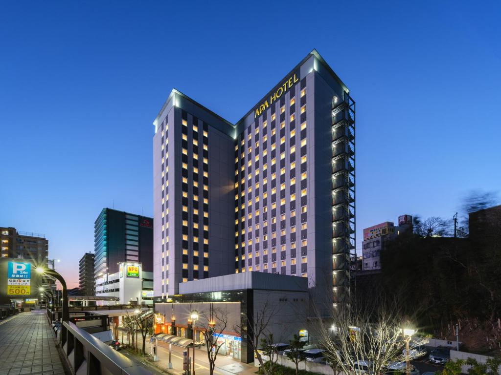 un edificio alto con muchas ventanas en una ciudad en APA Hotel Keisei Narita Ekimae en Narita