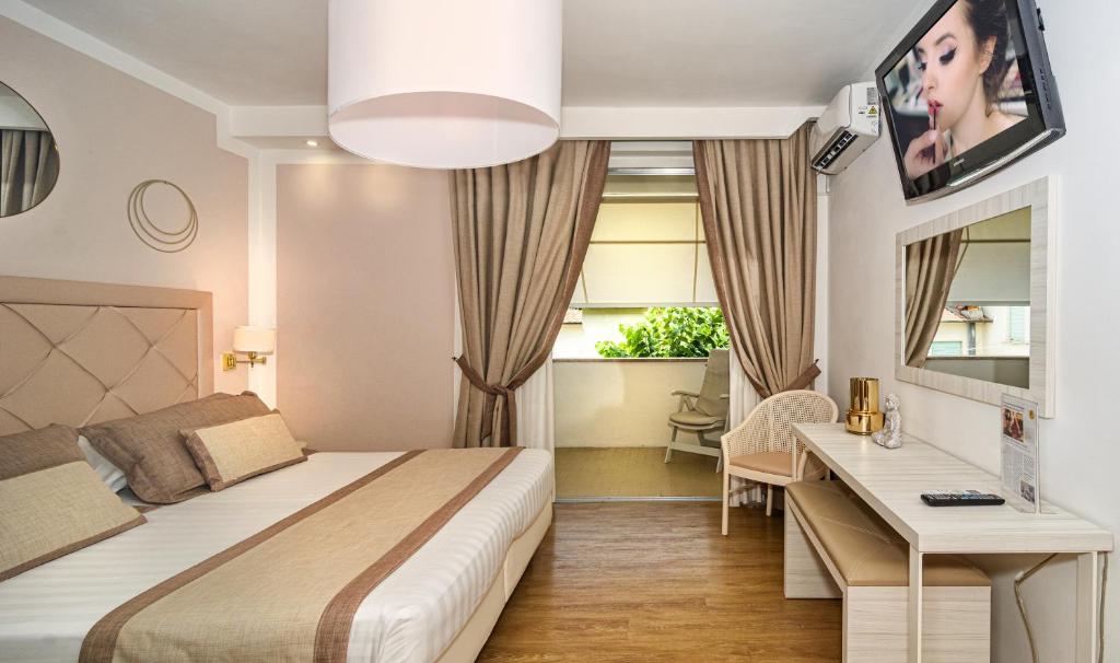 Pokój hotelowy z łóżkiem i biurkiem w obiekcie Raffaelli Park Hotel w mieście Forte dei Marmi
