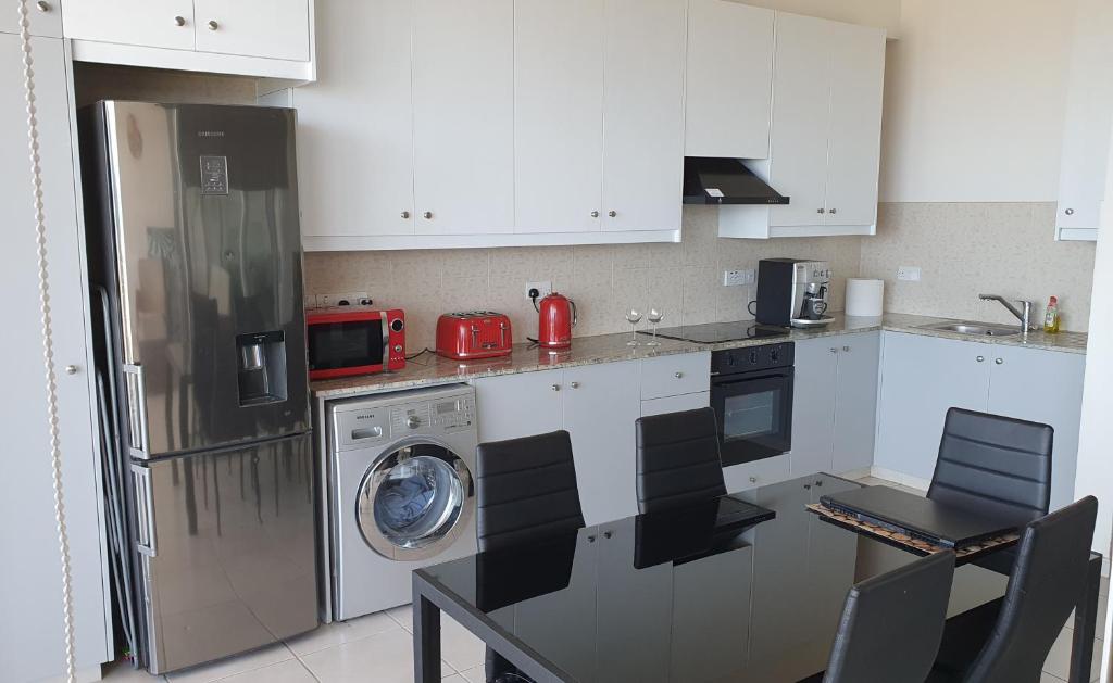 a kitchen with a refrigerator and a washing machine at Aphrodite Heights in Larnaka