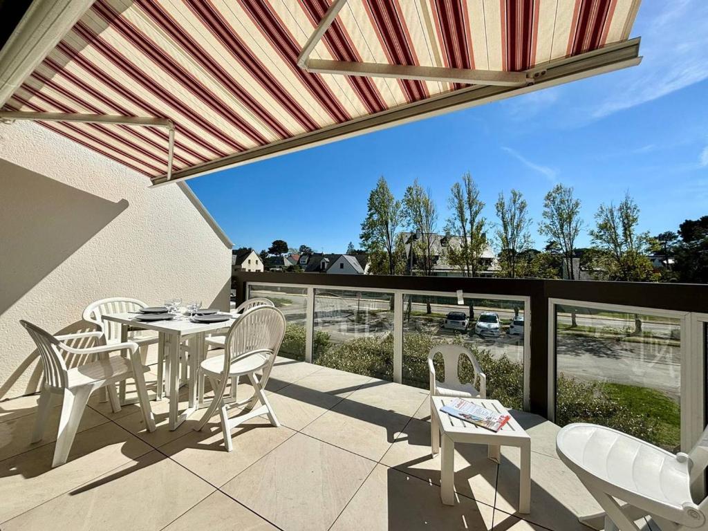 un patio avec une table et des chaises sur un balcon dans l'établissement Appartement 3 pièces à Carnac, balcon sud, proche plage - 4 pers - FR-1-377-14, à Carnac