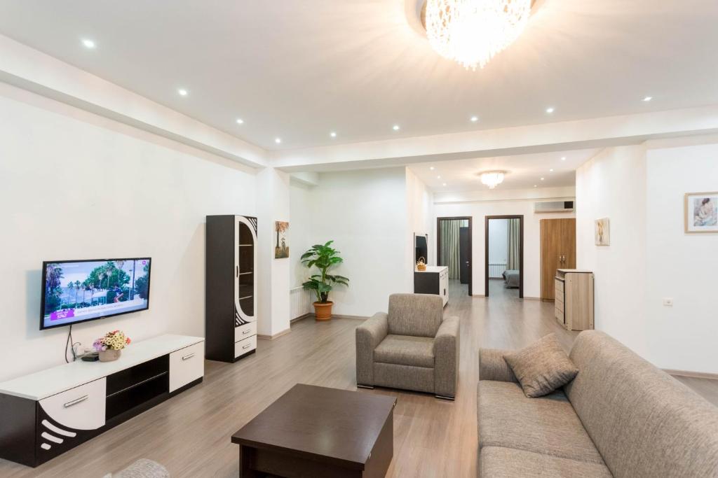 een woonkamer met een bank en een tv bij Premium 2 Bedroom Apartment lll in Tbilisi City