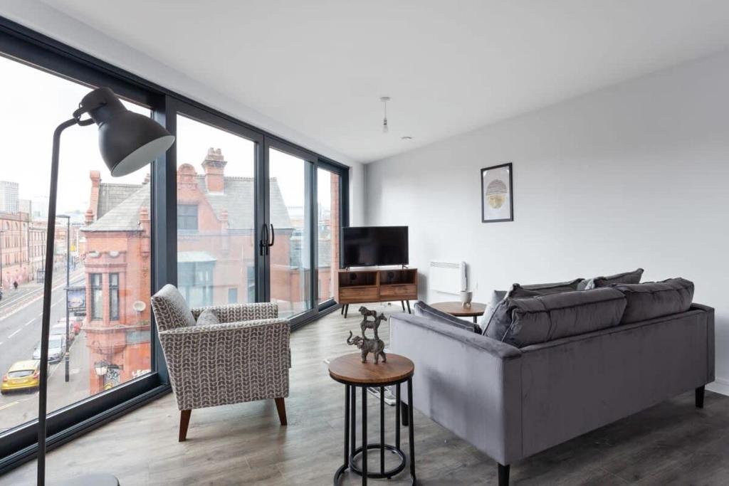 uma sala de estar com um sofá e uma cadeira em Modern & Spacious Apartment In Central Birmingham em Birmingham