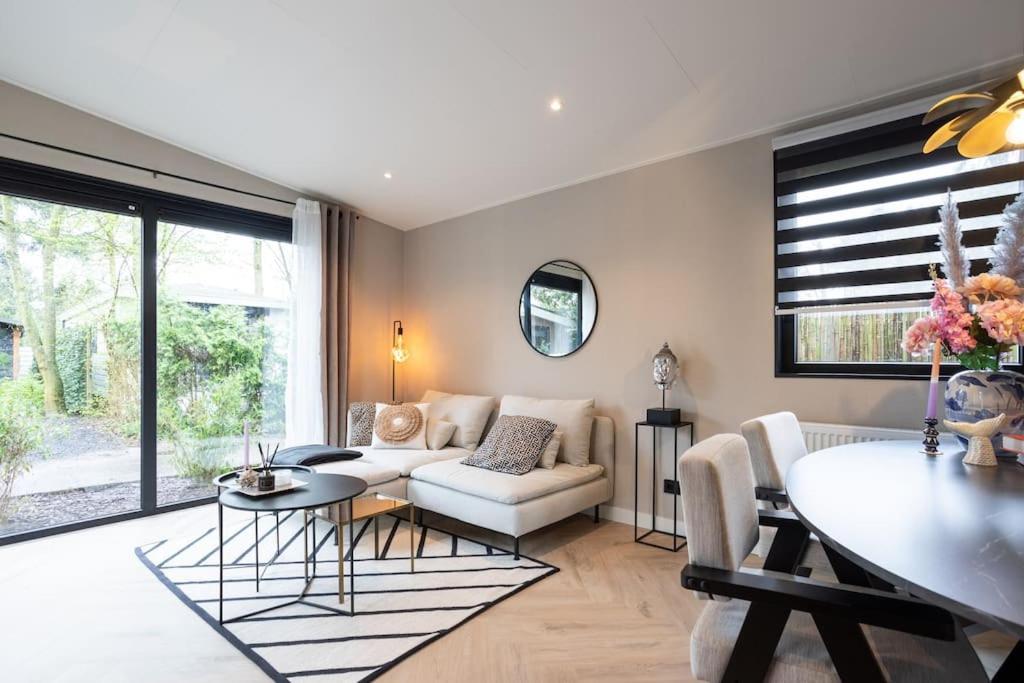 a living room with a couch and a table at Veluwe Boutique Lodge in Putten