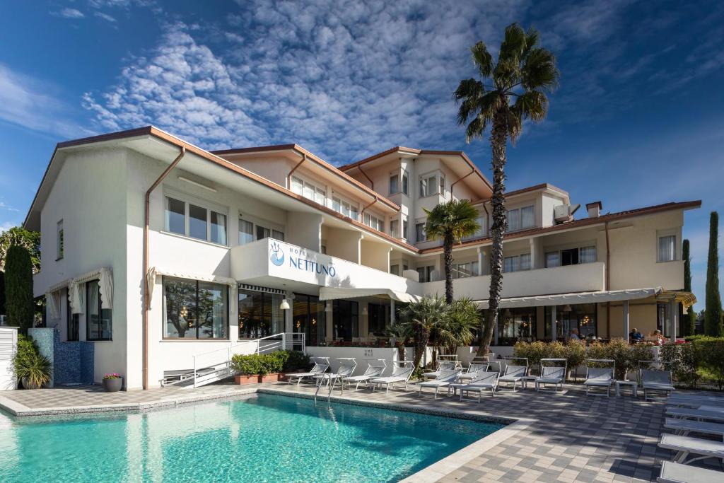 a hotel with a swimming pool in front of a building at Hotel Nettuno in Bardolino