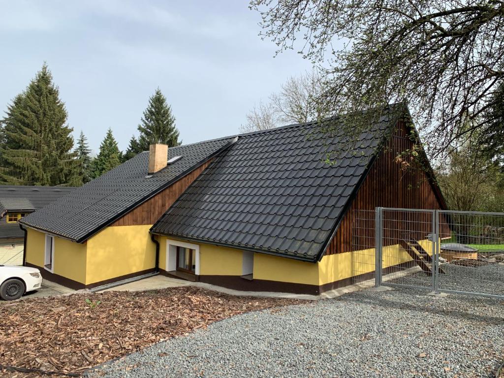 uma casa castanha e amarela com telhado em chata-brdy em Nové Mitrovice