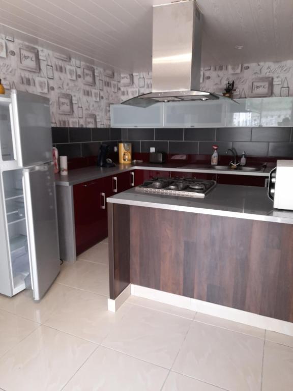 une cuisine avec une cuisinière et un réfrigérateur dans l'établissement GÏTE MARIA, à Laruns