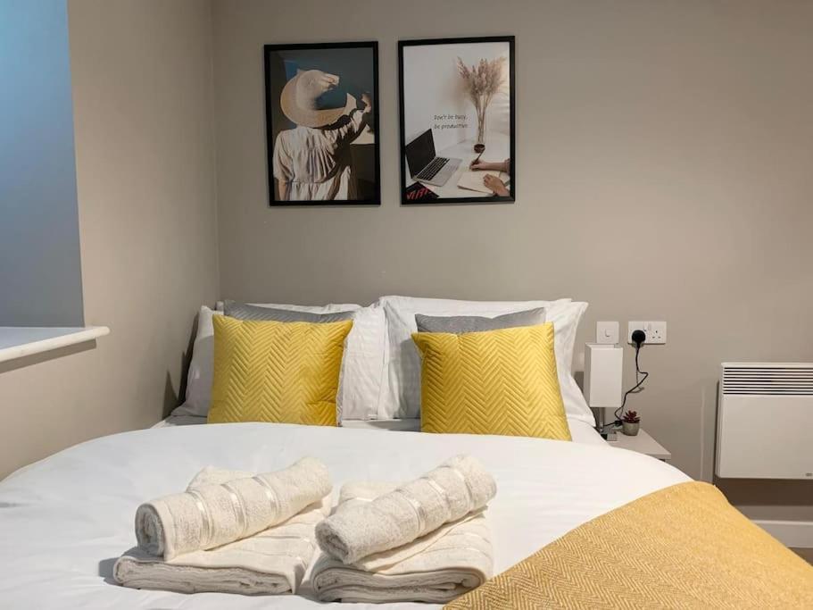 a bedroom with a white bed with three pictures on the wall at HNFC Stays - Prime Central Newcastle Studio w/ Gym+Free parking in Newcastle upon Tyne