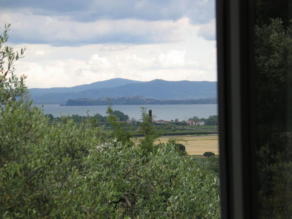 a view of a lake and mountains from a window at Casa Girella in Terontola