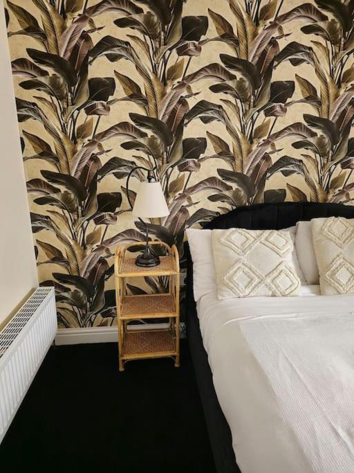 a bedroom with a bed and a table with a lamp at Homely one bed apartment on main road with easy access to city or Peak District in Heeley