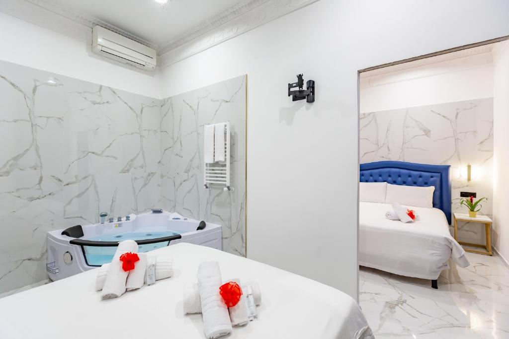 ein weißes Schlafzimmer mit einer Badewanne und einem Bett in der Unterkunft Miss Suite in Rom