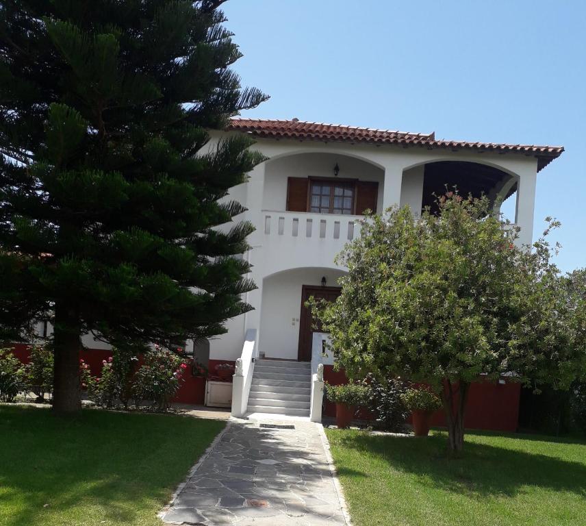 een wit huis met bomen ervoor bij Family Villa Dora in Zakharo