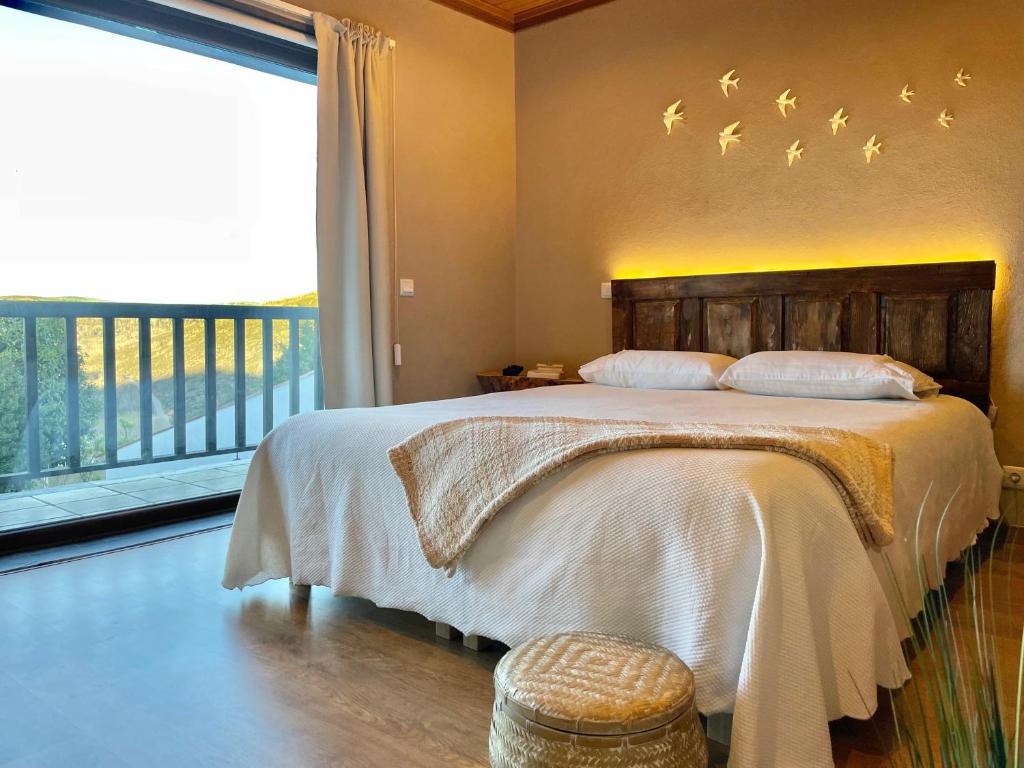 1 dormitorio con 1 cama con pájaros en la pared en Sweet Quintanilha 