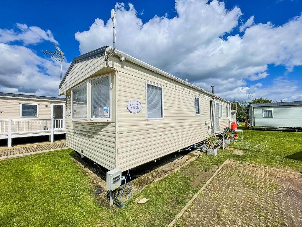 a large white caravan parked in a yard at Lovely 8 Berth Caravan With Wifi At Dovercourt Holiday Park Ref 44002d in Great Oakley