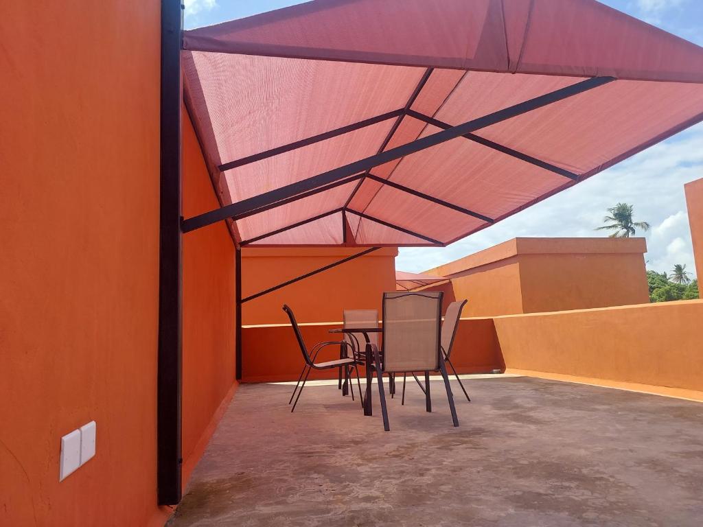 a patio with a table and chairs under a roof at Jamiitown Homes in Kilifi