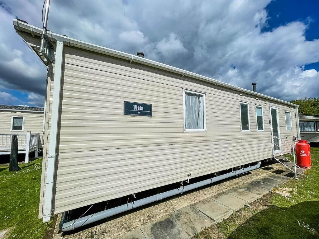 a white house with a sign on the side of it at 8 Berth Caravan At Dovercourt Holiday Park In Essex Ref 44002p in Great Oakley