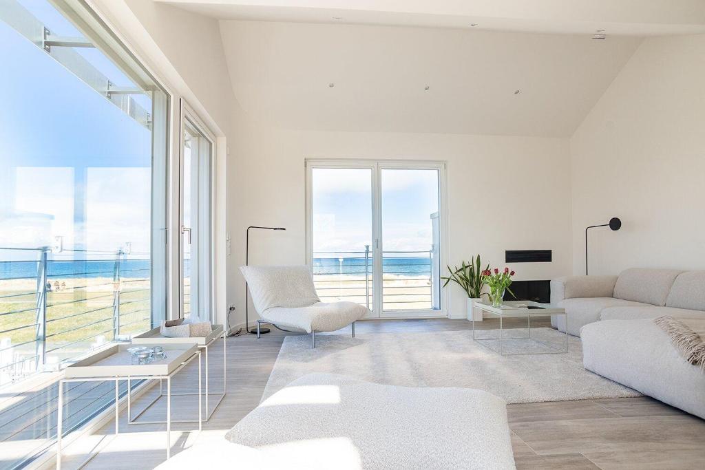 una sala de estar con muebles blancos y vistas al océano. en Ferienwohnung Steuerbord, en Kalifornien