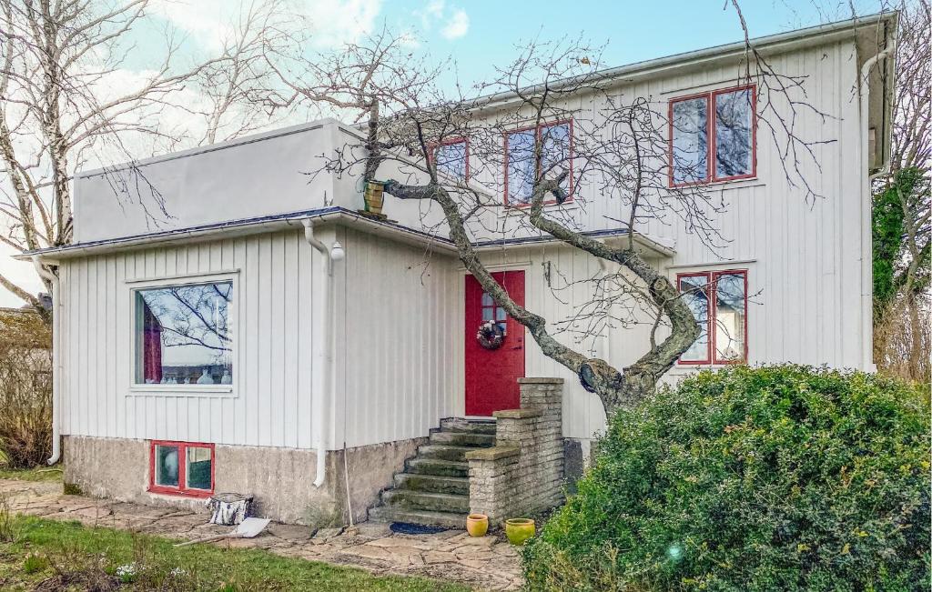 une maison blanche avec une porte rouge dans l'établissement 4 Bedroom Nice Home In Mrbylnga, à Mörbylånga