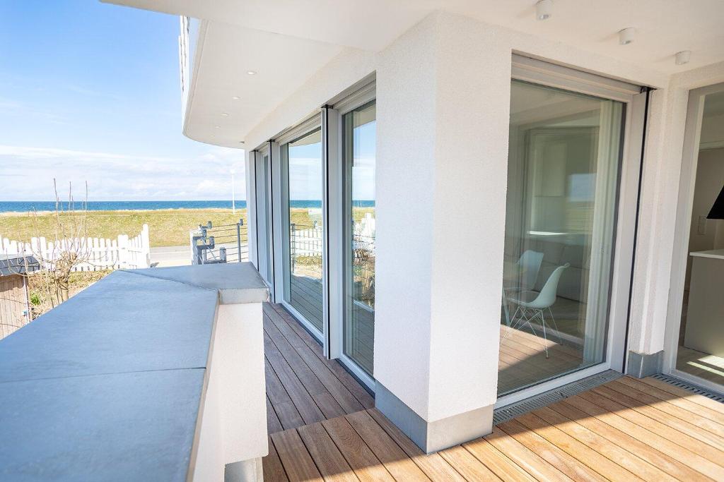 een balkon met glazen schuifdeuren en uitzicht op de oceaan bij Ferienwohnung Backbord in Kalifornien