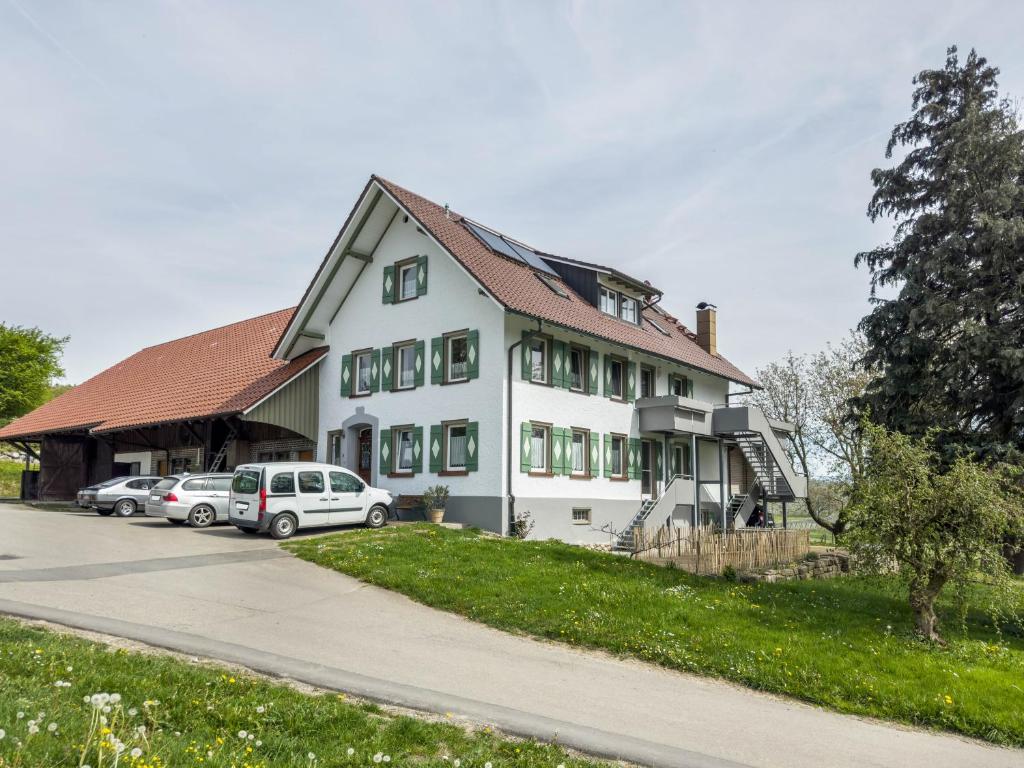 a white house with cars parked in front of it at Ferienwohnung Lang in Kressbronn am Bodensee