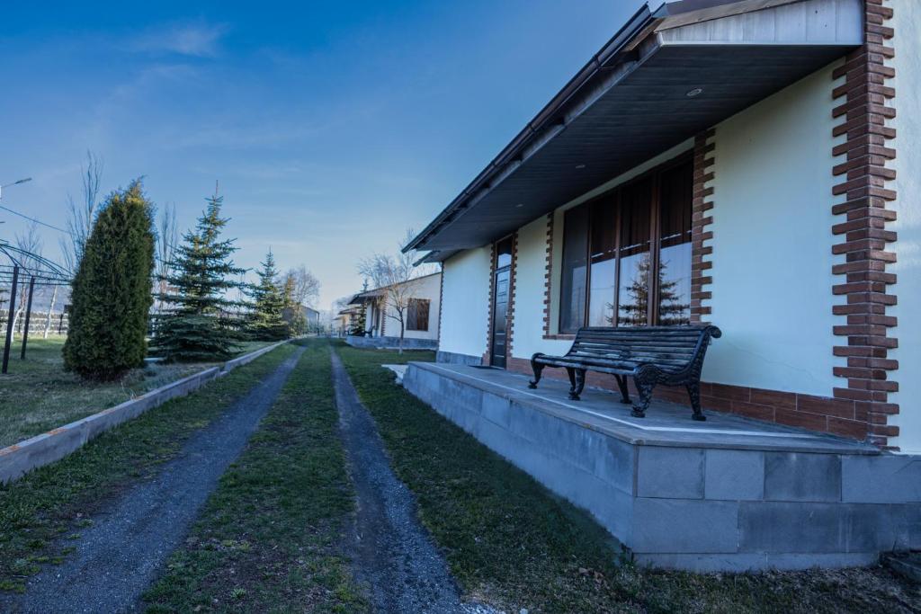 un banco sentado en el porche de un edificio en Sevan Private Guest House en Sevan