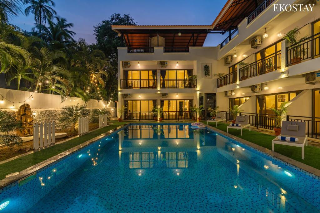 a villa with a swimming pool at night at Ekostay Gold Sea Shore Villa I Rooftop Turf I 100 Meters away from the Beach in Alibaug