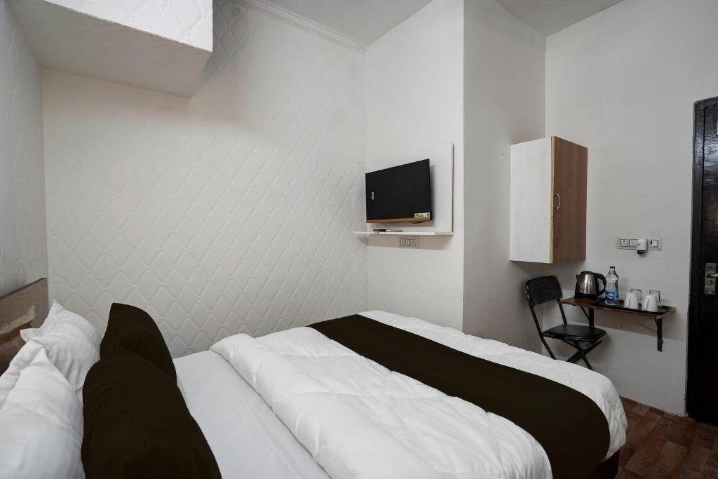 a bedroom with a bed and a tv on the wall at OYO Kiiza Stay House in New Delhi